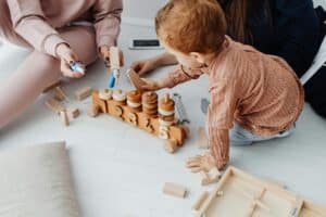 A toddler plays with a set of wooden stacking toys