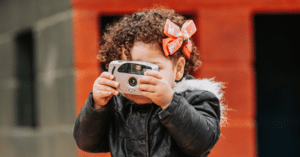 Toddler girl using a camera